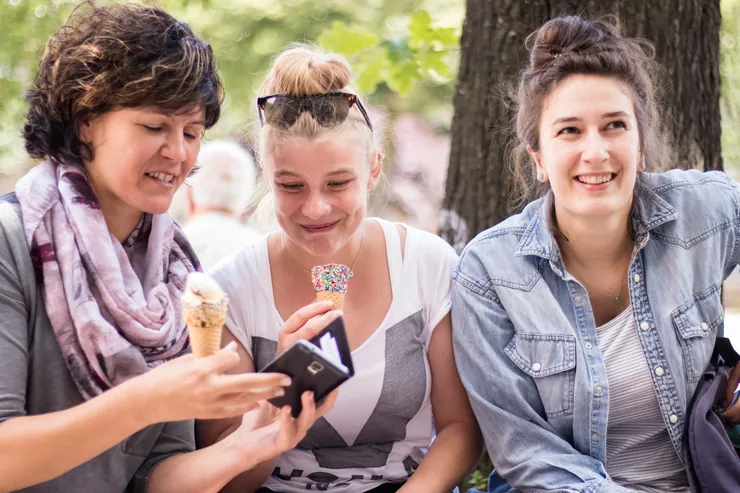 Drei Schülerinnen genießen draußen eine Pause mit Eis Drei Schülerinnen genießen draußen eine Pause mit Eis